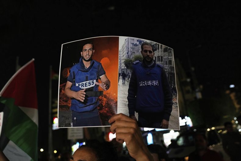 Una mujer lleva un cartel que muestra a los periodistas palestinos Anas al-Sharif, a la izquierda, y Mohamed Qreiqeh, a quienes el ejército de Israel atacó y mató con un ataque aéreo el domingo por la noche en Gaza, durante una protesta en la ciudad cisjordana de Ramallah el lunes 11 de agosto de 2025. (Foto AP/Nasser Nasser)