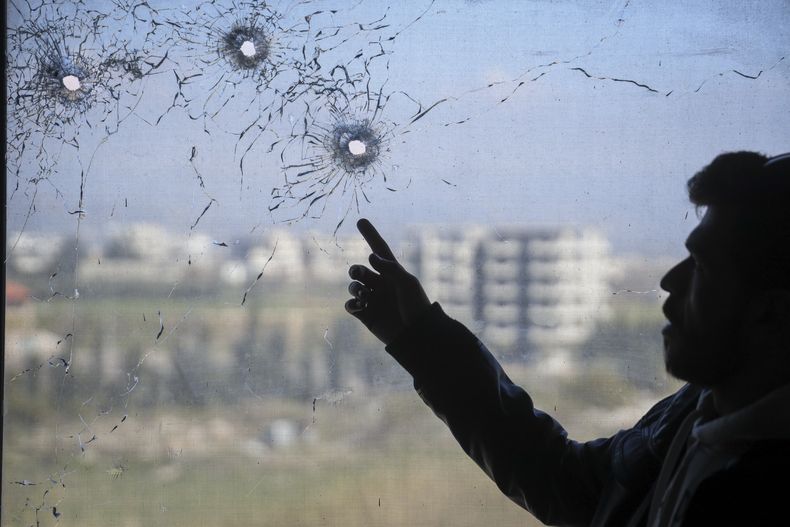 Una persona señala agujeros de bala tras una reciente ola de violencia entre fuerzas de seguridad sirias y milicianos leales al derrocado presidente Bashar Assad, y ataques sectarios subsiguientes, en un hospital en el pueblo de Jableh, Siria, el 10 de marzo del 2025. (AP foto/Omar Albam)