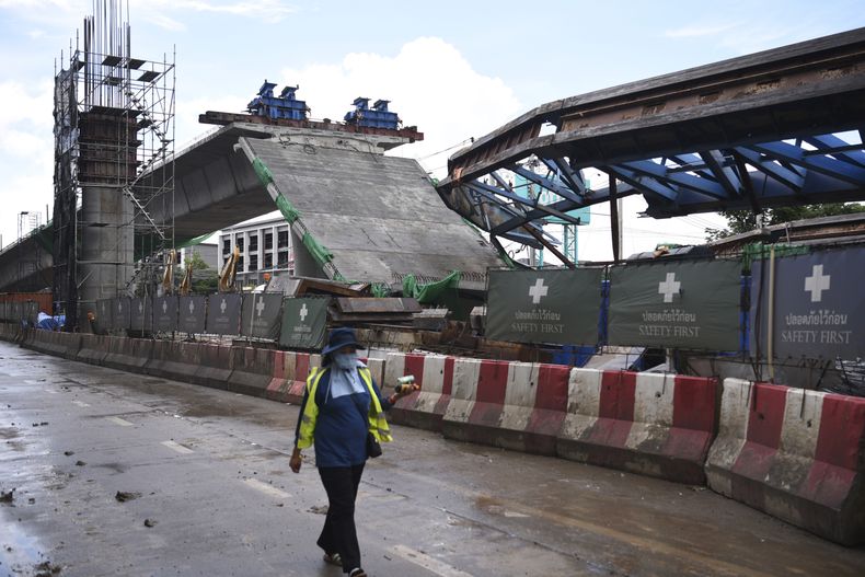 Un trabajador pasa junto a una zona derrumbada de una carretera elevada en Bangkok, el martes 11 de julio de 2023. (AP Foto/Thanchote Thanawikran)