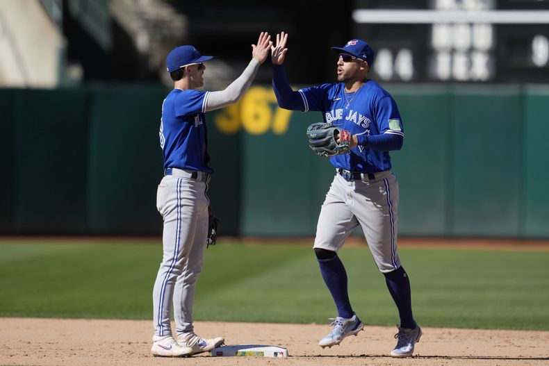 Cavan Biggio (izquierda) de los Azulejos de Toronto celebra junto a su compañero George Springer, el triunfo sobre los Atléticos de Oakland. (AP Foto/Jeff Chiu)