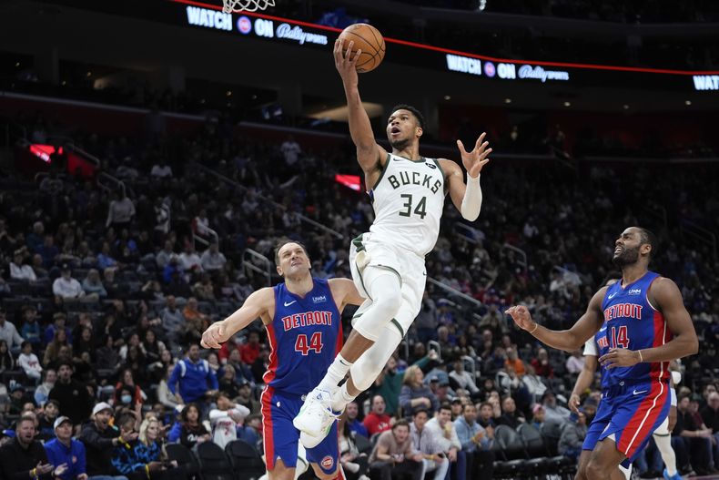 Giannis Antetokounmpo, de los Bucks de Milwaukee, salta para encestar frente a Bojan Bogdanovic, alero de los Pistons de Detroit, en el duelo del sábado 20 de enero de 2024 (AP Foto/Paul Sancya)