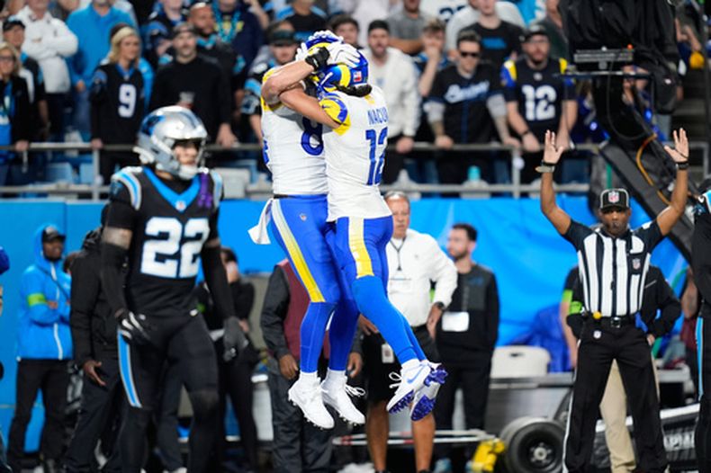Colby Parkinson (centro-izquierda) festeja su recepción de touchdown con su compañero Puka Nacua en el encuentro de comodines ante los Panthers de Carolina, el sábado 10 de enero de 2026 (AP Foto/Erik Verduzco)