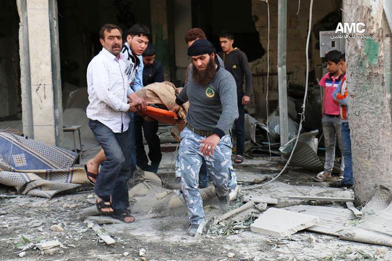 Esta foto suministrada por el grupo activista Aleppo Media Center (AMC), que ha sido autenticada en base a su conetnido y otros reportajes de la AP, muestra a sirios transportando un cad&aacute;ver despu&eacute;s de un ataque a&eacute;reo del gobierno en