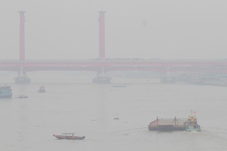 Barcos navegan por el río Musi envueltos en el humo de los incendios en Palembang, Sumatra del Sur, Indonesia, el 9 de septiembre de 2026. (AP Foto/Muhammad Hatta)