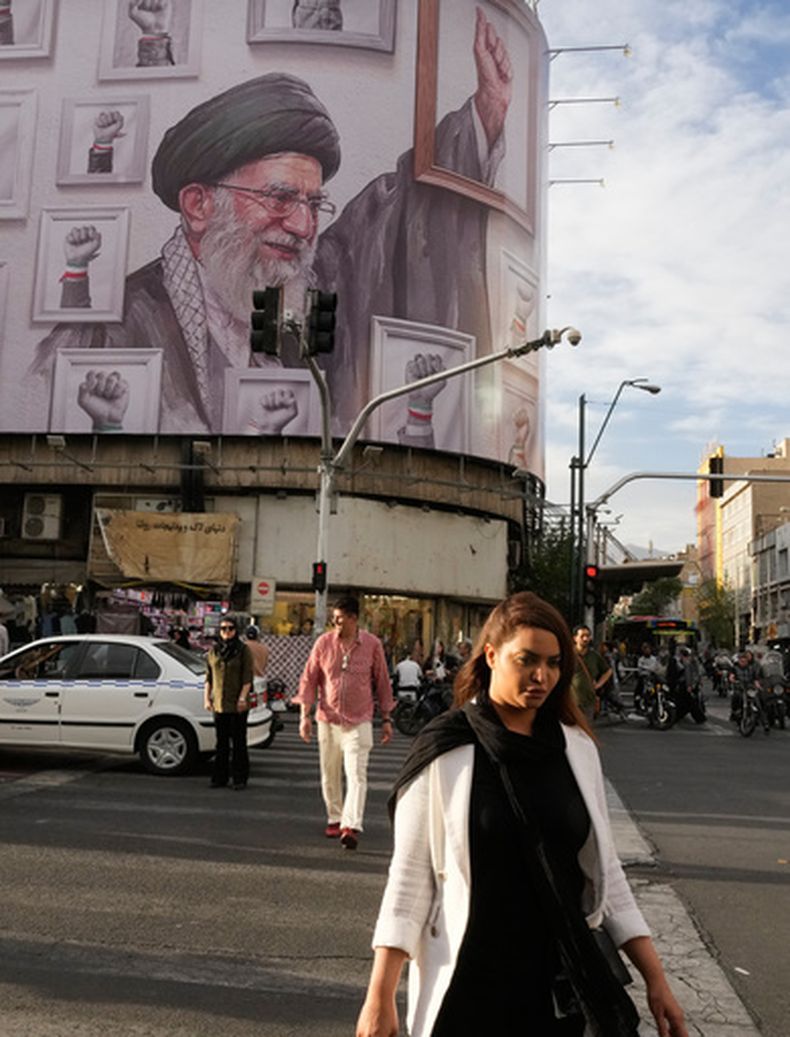 Personas caminan cerca de una valla publicitaria con una imagen del difunto líder supremo iraní, el ayatolá Alí Jamenei, en el centro de Teherán, Irán, el miércoles 6 de mayo de 2026. (AP Foto/Vahid Salemi)