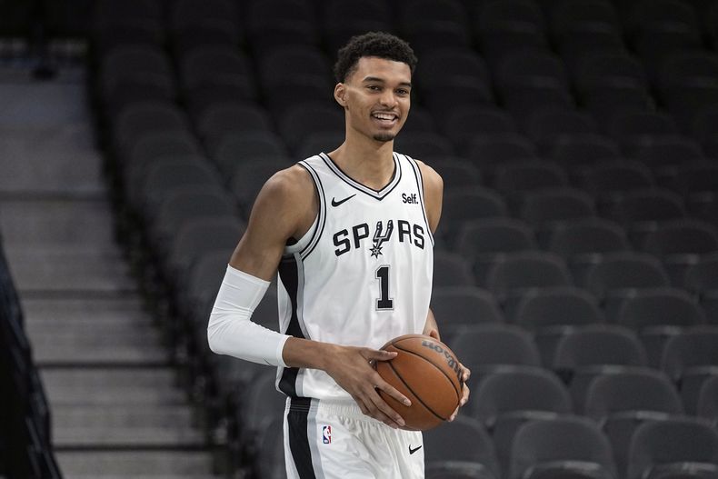 Victor Wembanyama, primera selección del draft de la NBA, escogido por los Spurs de San Antonio sostiene la bola durante una conferencia de prensa de la NBA en el AT&T Center en San Antonio. Sábado 24 de junio de 2023. (AP Foto/Eric Gay)