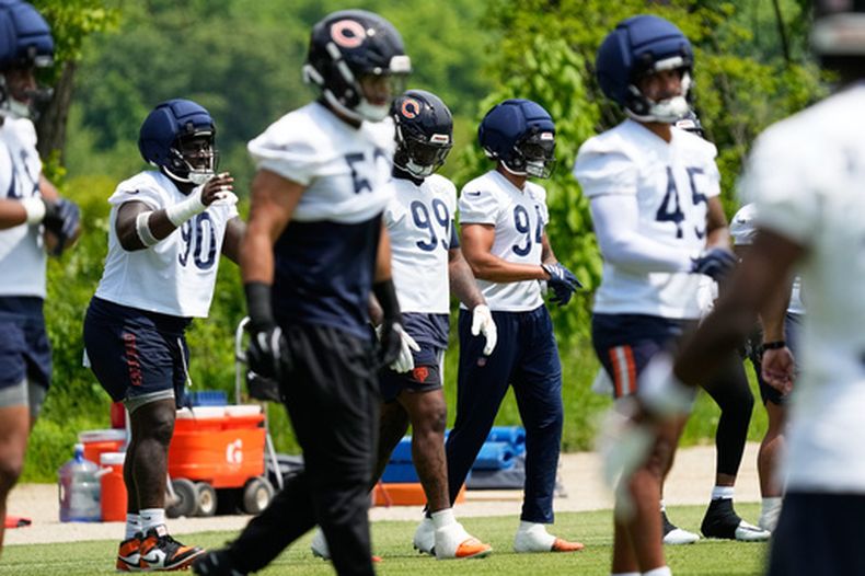 Los lineman Neville Gallimore (90), Gervon Dexter Sr. (99) y Austin Booker (94) durante un entrenamiento de los Bears de Chicago, el miércoles 3 de junio de 2026, en Lake Forest, Illinois. (AP Foto/Nam Y. Huh)