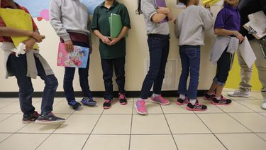 Adolescentes inmigrantes hacen fila para una clase en un centro para menores el 29 de agosto de 2019, en el Rio Grande Valley, en San Benito, Texas. (AP Foto/Archivo Eric Gay)