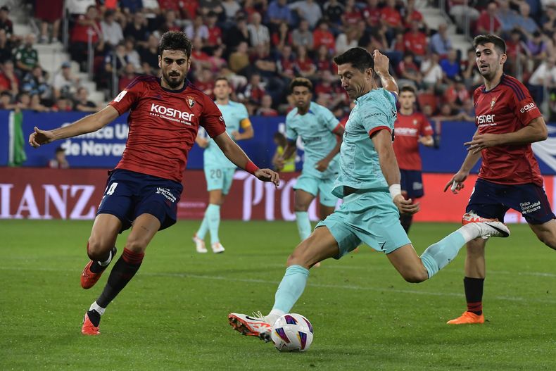 Robert Lewandowski del Barcelona dispara el balón superando a Alejandro Catena del Osasuna en el encuentro de la liga española el domingo 3 de septiembre del 2023. (AP Foto/Alvaro Barrientos)