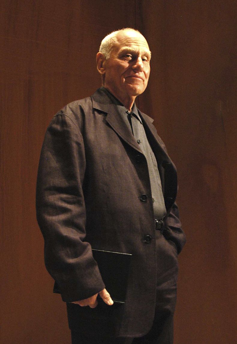 ARCHIVO - El escultor estadounidense Richard Serra entra al Museo Guggenheim en Bilbao, España, para inauguruar una exposición con ocho enormes esculturas oxidadas titulada The Matter of Time (La materia del tiempo), el 7 de junio de 2005. Serra, conocido por convertir paredes curvas de acero oxidado y otros materiales maleables en obras de arte a gran escala que ahora están repartidas por todo el mundo, murió el martes 26 de marzo de 2024 en su casa en Long Island, Nueva York. Tenía 85 años. (Foto AP/Ander Gillenea, archivo)