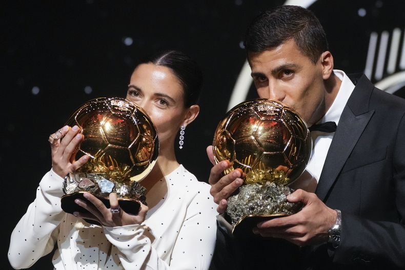 La futbolista española Aitana Bonmati y su compatriota Rodrile dan un beso al trofeo tras ganar el Balón de Oro en la ceremonia en París el lunes 28 de octubre del 2024. (AP Foto/Michel Euler)