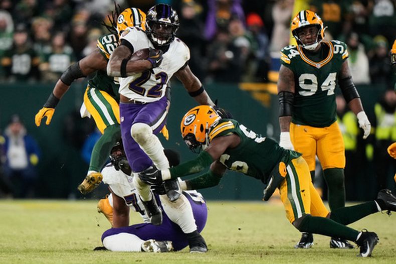 Derrick Henry (22), de los Ravens de Baltimore, corre con el balón sobre Edgerrin Cooper (56) y Rashan Gary (52), de los Packers de Green Bay, durante la segunda mitad del partido de la NFL del sábado 27 de diciembre de 2025, en Green Bay, Wisconsin. (AP Foto/Morry Gash)