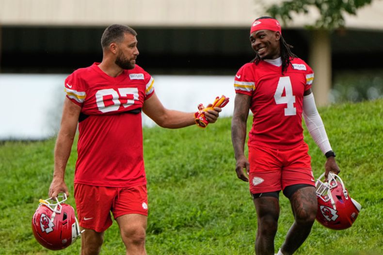 El ala cerrada de los Chiefs de Kansas City, Travis Kelce (87), y el receptor abierto Rashee Rice (4) caminan hacia el campamento de entrenamiento de fútbol americano de la NFL el viernes 31 de julio de 2026, en St. Joseph, Misuri. (Foto AP/Charlie Riedel)