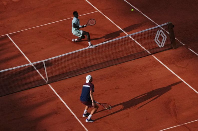 Alejandro Tabilo (abajo) juega contra Moise Kouame en la tercera ronda de Roland Garros, el sábado 30 de mayo de 2026, en París. (AP Foto/Christophe Ena)
