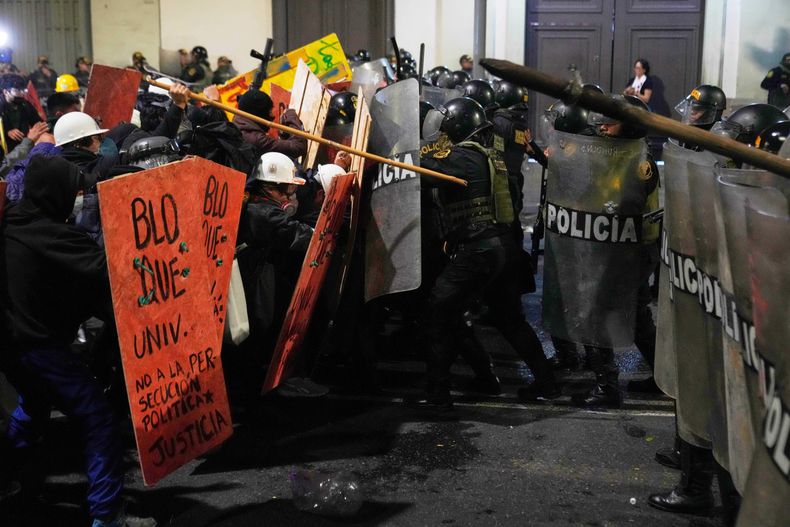 Manifestantes que enfrentan con policías antimotines cerca del Congreso durante una protesta contra el nuevo presidente, José Jeri, en Lima, Perú, el 15 de octubre de 2025. (AP Foto/Martín Mejía)