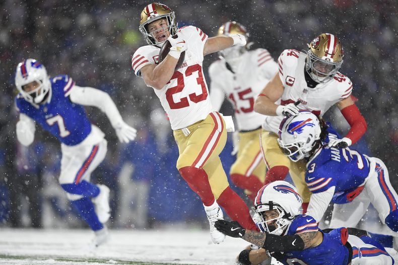 Christian McCaffrey (23), running back de los 49ers de San Francisco, corre con el balón mientras Taylor Rapp, abajo, de los Bills de Buffalo, lo trompica durante la primera mitad del juego de la NFL del domingo 1 de diciembre de 2024, en Orchard Park, Nueva York. (AP Foto/Adrian Kraus)
