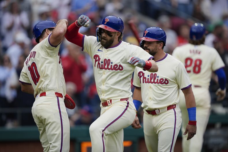Bryce Harper, centro, de los Filis de Filadelfia, celebra con J.T. Realmuto, izquierda, y Kyle Schwarber después de disparar cuadrangular de tres carreras frente al debutante de los Gigantes de San Francisco Mason Black durante la quinta entrada del juego de béisbol, el lunes 6 de mayo de 2024, en Filadelfia. (AP Foto/Matt Rourke)
