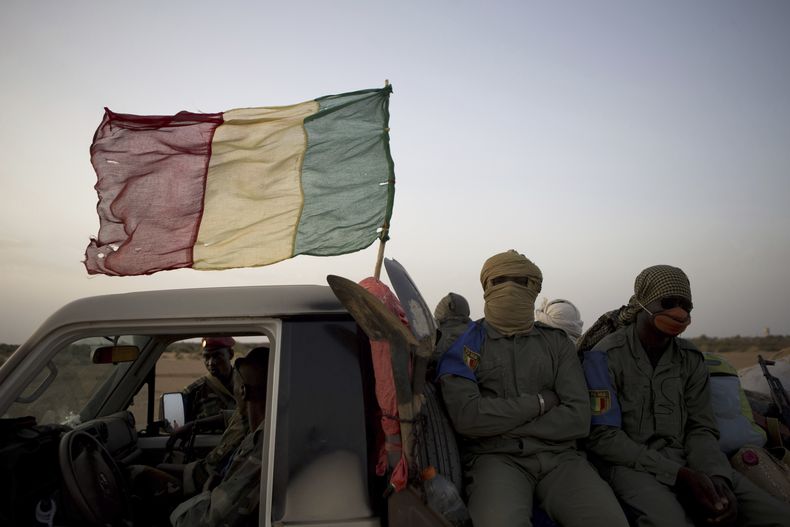 ARCHIVO -Comandos del ejército de Mali a bordo de un convoy en un camino en las afueras de Gao, Mali, el 26 de julio de 2013. (AP Foto/Rebecca Blackwell, Archivo)