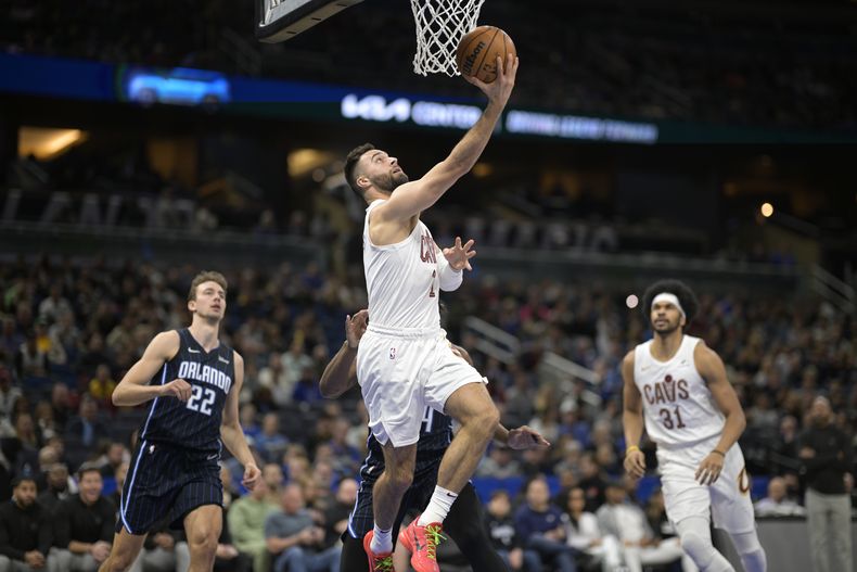 Max Strus, de los Cavaliers de Cleveland, se alza paa dejar una bandeja frente a Wendell Carter Jr., del Magic de Orlando, mientraas Franz Wagner (22) y Jarrett Allen (31) observan la acción durante la primera mitad del juego de baloncesto de la NBA, el lunes 22 de enero de 2024, en Orlando, Florida. (AP Foto/Phelan M. Ebenhack)