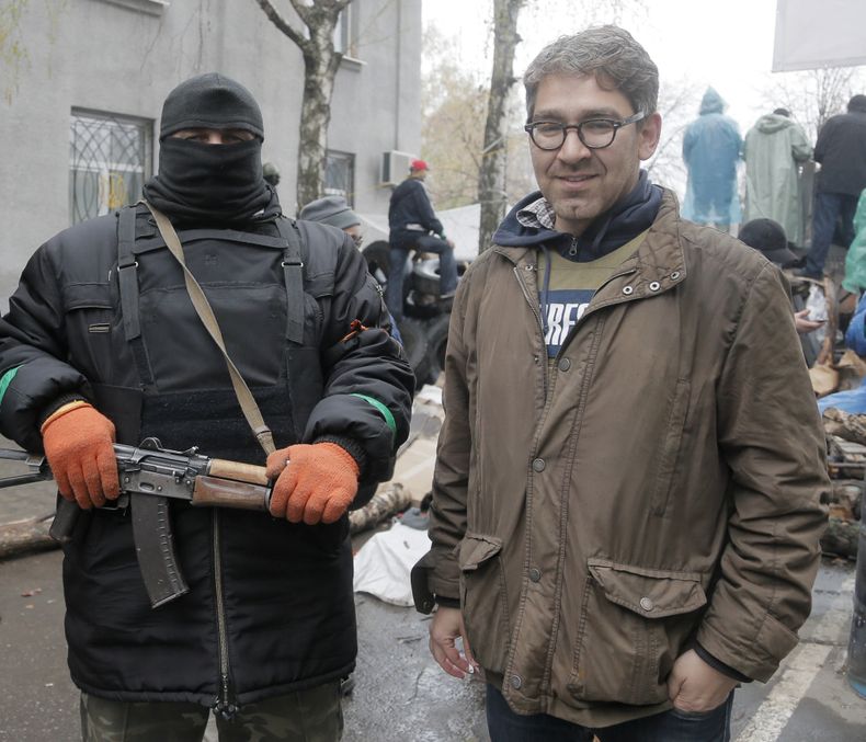En imagen tomada el 13 de abril de 2014 el periodista Simon Ostrovsky (derecha) posa junto a un hombre armado simpatizante de Rusia en una estaci&oacute;n de polic&iacute;a ocuopada por los insurgentes. Ostrovsky, periodista que trabaja para Vice News, no