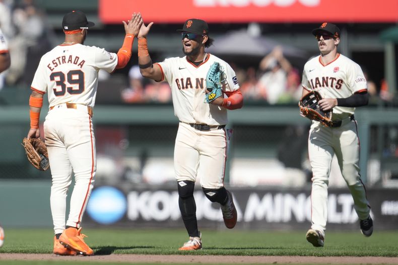 El segunda base de los Gigantes de San Francisco, Thairo Estrada (39), celebra con el jardinero central Luis Matos, el centro, y el jardinero derecho Mike Yastrzemski, a la derecha, después de que derrotaron a los Filis de Filadelfia en un juego de béisbol en San Francisco, el lunes 27 de mayo de 2024. (AP Foto/Jeff Chiu)
