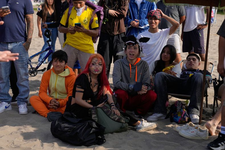 Jóvenes esperan su turno para competir en batallas de farmear aura en la playa Las Sombrillas de Lima, Perú, el sábado 29 de agosto de 2026. (AP Foto/Martín Mejía)