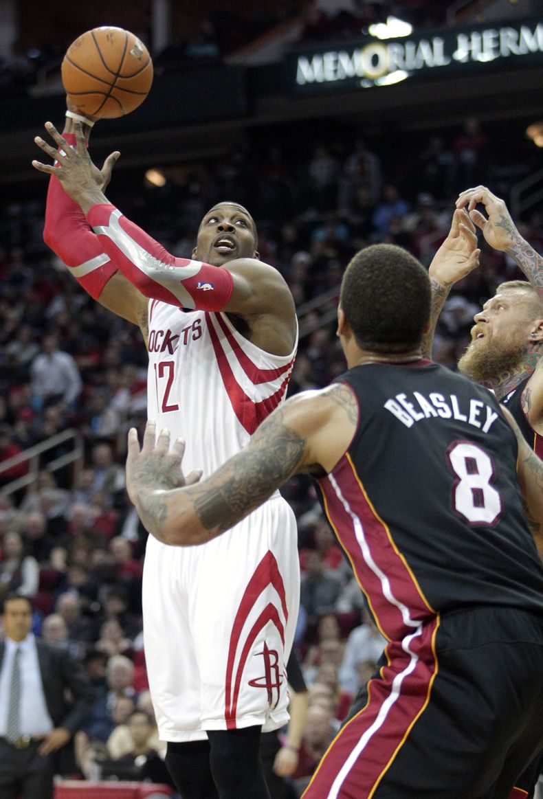 Dwight Howard, p&iacute;vot de los Rockets de Houston, realiza un disparo frente a Michael Beasley, del Heat de Miami, durante el &uacute;ltimo cuarto del partido del martes 4 de marzo de 2014 (AP Foto/Patric Schneider)