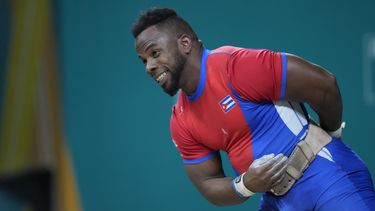 El cubano Olfides Sáez hace un gesto tras levantar una pesa en la categoría de 89 kilogramos de los Juegos Panamericanos en Santiago, el domingo 22 de octubre de 2023 (AP Foto/Moisés Castillo)