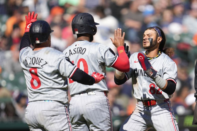 Christian Vázquez, Willi Castro y Austin Martin de los Mellizos de Minnesota celebra tras anotar en la 12ma entrada ante los Tigres de Detroit en el primer juego de una doble cartelera el sábado 13 de abril del 2024. (AP Foto/Paul Sancya)
