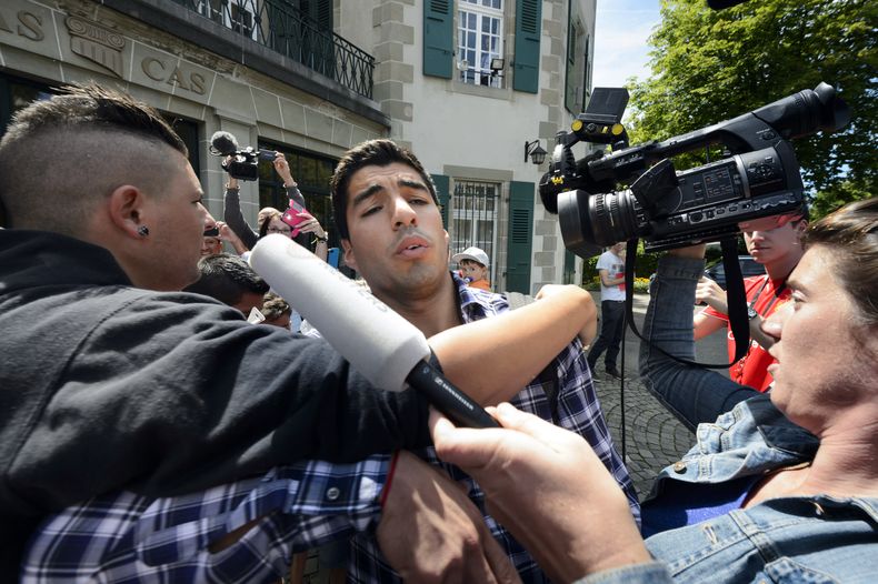 Un fan&aacute;tico intenta abrazar al futbolista uruguayo Luis Su&aacute;rez a la salida del Tribunal de Arbitraje Deportivo el viernes, 8 de agosto de 2014, en Lausana, Suiza. (AP Photo/Keystone, Laurent Gillieron)