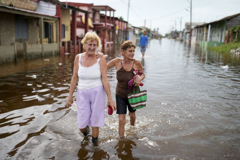 Los residentes caminan por una calle inundada tras el paso del huracán Rafael en Batabano, Cuba, el jueves 7 de noviembre de 2024. (Foto AP/Ramón Espinosa)