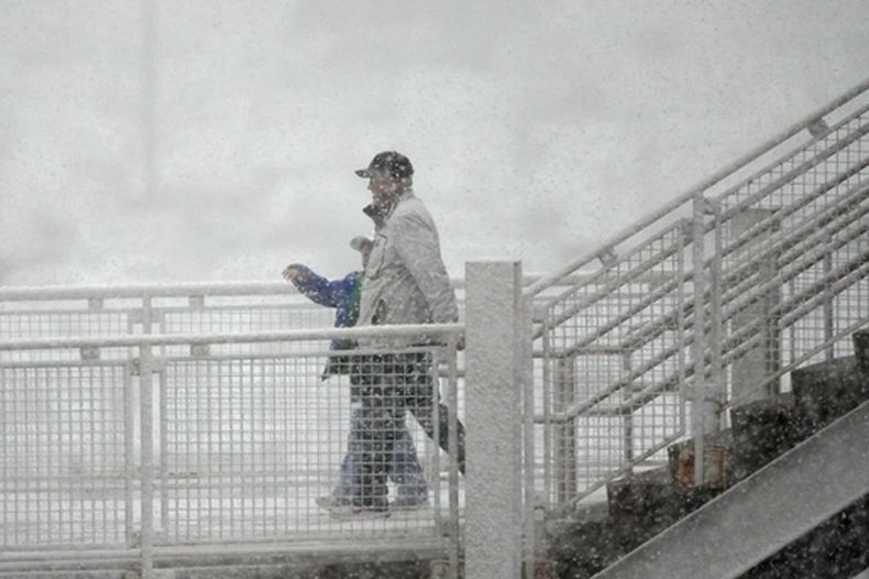 Aficionados al hockey se dirigen al Ball Arena mientras una nevada de primavera pasa por la zona antes del primer tiempo del Juego 2 de la segunda ronda de playoff de la Stanley Cup de NHL entre el Avalanche de Colorado y el Wild de Minnesota, el martes 4 de mayo de 2026, en Denver. (AP foto/David Zalubowski)
