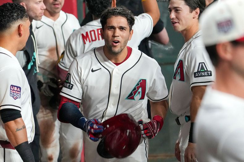 Adrian del Castillo, centro, de los Diamondbacks de Arizona, celebra con sus compañeros después de batear un cuadrangular de tres carreras en la primera entrada del juego de béisbol de Grandes Ligas contra los Cerveceros de Milwaukee, el sábado 4 de julio de 2026, en Phoenix. (AP Foto/Darryl Webb)