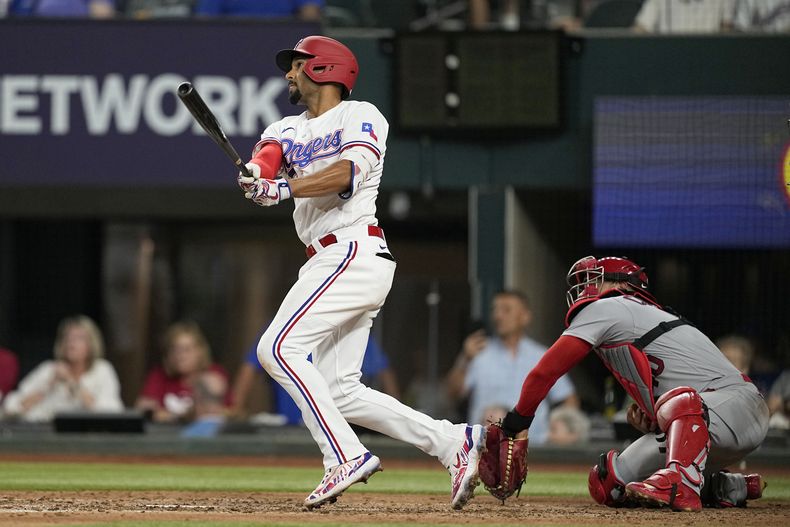 Marcus Semien, de los Rangers de Texas, conecta un doblete delante del cátcher venezolano Willson Contreras, de los Cardenales de San Luis, el martes 6 de junio de 2023 (AP Foto/Tony Gutiérrez)