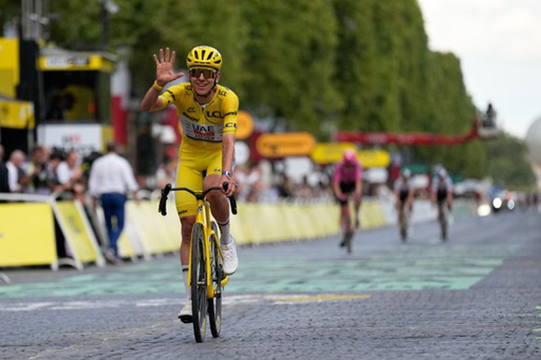 El esloveno Tadej Pogacar, vistiendo el maillot amarillo de líder general, celebra al cruzar la línea de meta de la última etapa de la carrera ciclista del Tour de Francia con salida y llegada en París, el domingo 26 de julio de 2026. (Foto AP/Mosaab Elshamy)