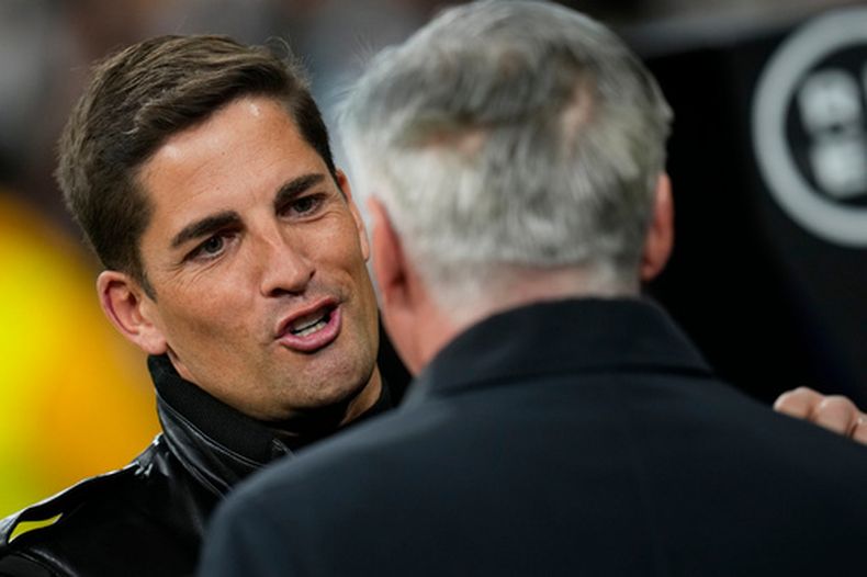 ARCHIVO - El entonces técnico de Granada Robert Moreno (izquierda) saluda a su contraparte de Real Madrid Carlo Ancelotti previo a un partido de La Liga española, el 6 de febrero de 2022, en Madrid. (AP Foto/Manu Fernández)