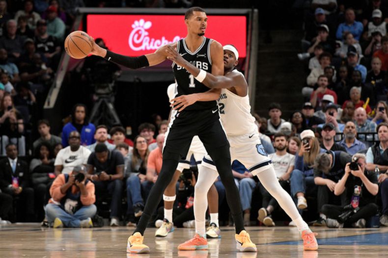 El alero de los Spurs de San Antonio, el francés Victor Wembanyama (1), controla el balón ante el alero de los Grizzlies de Memphis, Taylor Hendricks (22), en la primera mitad de un juego de baloncesto de la NBA, el miércoles 25 de marzo de 2026, en Memphis, Tennessee. (Foto AP/Brandon Dill)