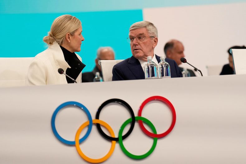 La presidenta del COI Kirsty Coventry conversa con su antecesor Thomas Bach en la apertura de la sesión del organismo, el martes 3 de febero de 2026, en Milán (AP foto/Luca Bruno)