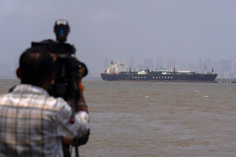 Un camarógrafo graba al petrolero con bandera india LPG Jag Vasant, que lleva gas licuado de petróleo, en el Puerto de Mumbai en Mumbai, India, tras pasar por el estrecho de Ormuz, el miércoles 1 de abril de 2026. (AP Foto/Rafiq Maqbool)