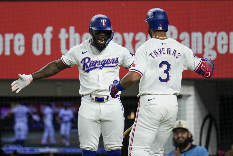 El cubano Adolis García felicita a su compañero de los Rangers de Texas, el dominicano Leody Taveras, quien conectó un jonrón de dos carreras en el juego del miércoles 19 de junio de 2024, ante los Mets de Nueva York (AP Foto/Julio Cortez)