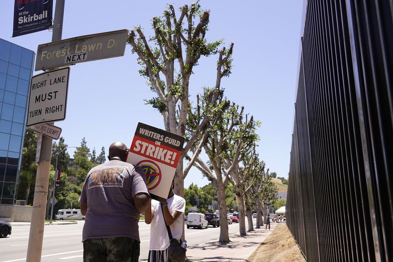 Manifestantes cerca de arboles recién podados fuera de Universal Studios el miércoles 19 de julio de 2023 en Burbank, California. (Foto AP/Chris Pizzello)