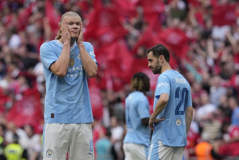 Erling Haaland (izquierda) y Bernardo Silva del Manchester City reacciona tras la derrota ante el Manchester United en la final de la Copa FA, el sábado 25 de mayo de 2024. (AP Foto/Kin Cheung)