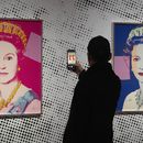 Un hombre toma una foto de una impresión en serigrafía que muestra a la Reina Isabel II, parte de la serie de dieciséis impresiones de cuatro reinas, titulada Reigning Queens, 1985, de Andy Warhol, en el museo Paleis Het Loo en Apeldoorn, Holanda, el miércoles 9 de octubre de 2024, similares a las obras del artista robadas de una galería de Oisterwijk, Holanda, en las primeras horas del viernes 1 de noviembre de 2024. (AP Foto/Peter Dejong)