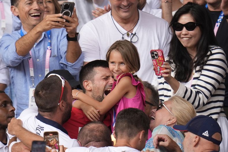 El serbio Novak Djokovic abraza a su hija Tara tras vencer al español Carlos Alcaraz en la final de sencillos masculino del tenis de los Juegos Olímpicos de París, el domingo 4 de agosto de 2024. (AP Foto/Manu Fernández)