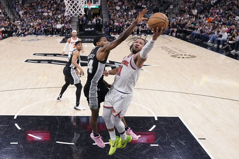 El base de los Knicks de Nueva York Jalen Brunson avanza hacia la canasta frente al base de los Spurs de San Antonio Blake Wesley en el encuentro del viernes 29 de marzo del 2024. (AP Foto/Eric Gay)