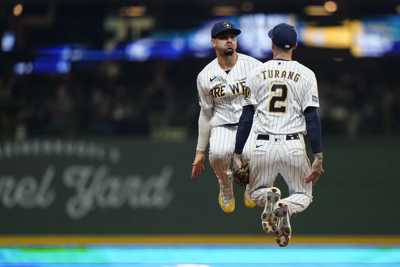 El dominicano Willy Adames y Brice Turang, de los Cerveceros de Milwaukee, festejan el triunfo sobre los Nacionales de Washington, el sábado 16 de septiembre de 2023 (AP Foto/Aaron Gash)
