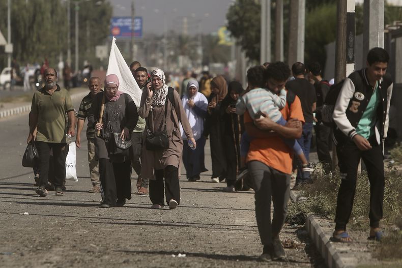 Una mujer carga con una bandera blanca para evitar recibir disparos mientras palestinos huyen de la Ciudad de Gaza hacia el sur de la Franja, en la calle Salah al-Din, en Bureij, el 7 de noviembre de 2023. (AP Foto/Mohammed Dahman)