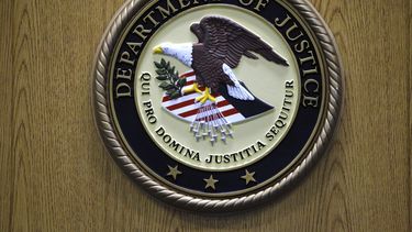 ARCHIVO - El logo del Departamento de Justicia es exhibido en un podio durante una conferencia de prensa, el 30 de septiembre de 2010, en Filadelfia. (AP Foto/Matt Slocum, archivo)