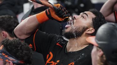 El venezolano Anthony Santander, de los Orioles de Baltimore, bebe agua de una manguera tras conectar un grand slam en el encuentro del viernes 5 de mayo de 2023, ante los Bravos de Atlanta (AP Foto/John Bazemore)