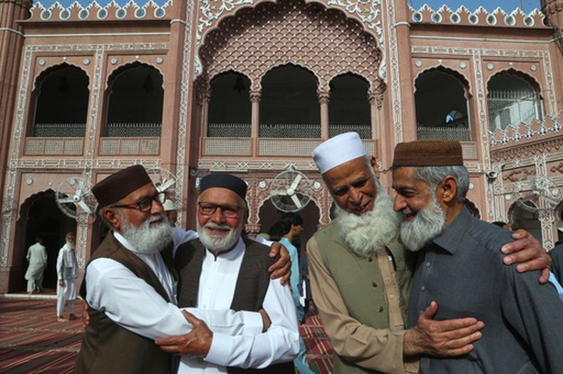 ARCHIVO - Musulmanes comparten buenos deseos en el Eid al-Fitr tras asistir a las plegarias del Eid, que marcan el final del mes musulmán sagrado del Ramadán, en la mezquita histórica de Sunehri, en Peshawar, Pakistán, el 31 de marzo de 2025. (AP Foto/Muhammad Sajjad, Archivo)